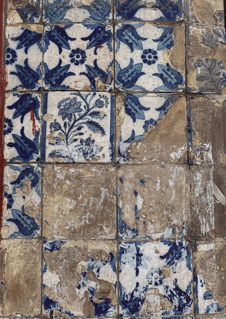 A weathered azulejo panel, blue on white, with several tiles missing